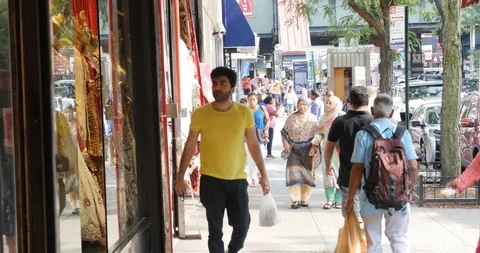 Handheld shot of man looking around while walking on sidewalk Stock Footage 120149627