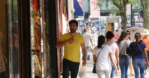 Handheld shot of man looking around while walking on sidewalk Stock Footage 120149653