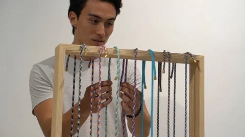 Handheld shot of man looking at craft jewellery at shore Stock-Footage 114849603