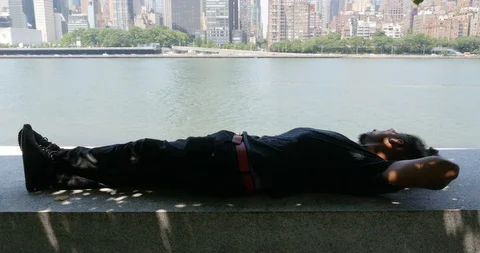 Handheld shot of man lying and relaxing on waterfront Stock Footage 120070886