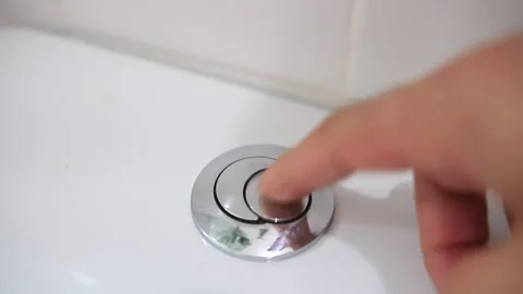 Handheld shot from a man pressing a button for flushing a toilet in Brazil Stock Footage 229809246