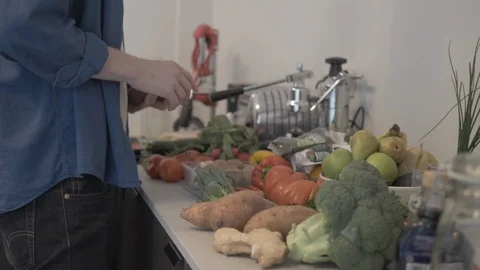Handheld shot of man selecting vegetables from kitchen counter 스톡 동영상 114842270