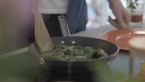 Handheld shot of man serving cooked green chillies on plate Stock Footage 114842314