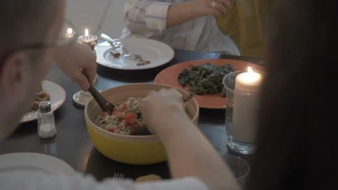 Handheld shot of man serving cooked brown rice to his friends on dinning table Stock Footage 114842467