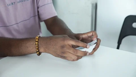 Handheld shot of man shuffling playing cards on table 스톡 동영상 114866376