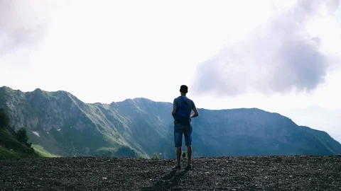 Handheld shot of man standing on cliff against sky Stock Footage 122520016