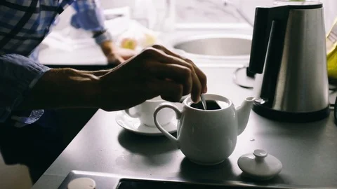 Handheld shot of man stirring tea in pot kept on table Stock Footage 122519462