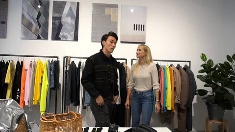 Handheld shot of man trying black jacket at store Vídeo Stock 114850414