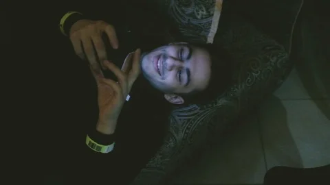 Handheld shot of man using his smartphone lying on sofa Stock Footage 122400240