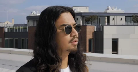 Handheld shot of man walking on rooftop and looking at view Stock Footage 120165636