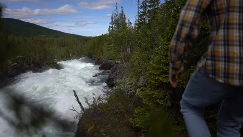Handheld shot of a man walking towards the river in the forest Stock-Footage 114882239