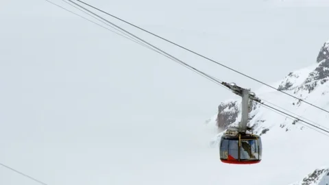 Handheld shot of modern cabin going up on cable railway in snowy mountains Stock Footage 129091123