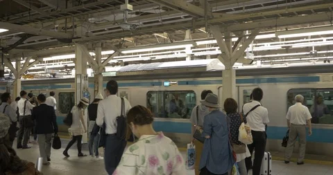 Handheld shot of a moving train in Tokyo, Japan with people exiting and entering Stock Footage 90067164