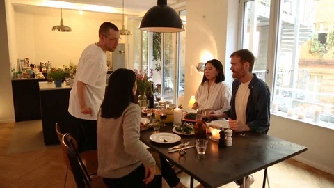 Handheld shot of multiracial friends at dining table Video stock 114846660
