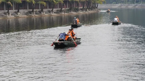 Handheld shot of native vietnamese people leaving harbour on rowing boats Stock Footage 147355426