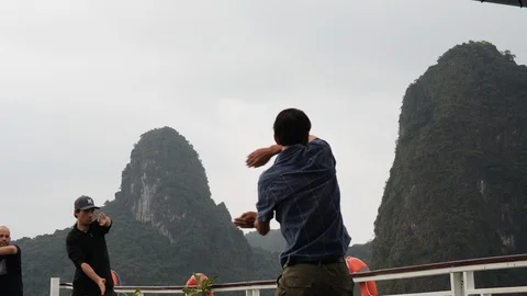 Handheld shot of native vietnamese people moving in sync on ship at Ha long bay Stock Footage 147356558