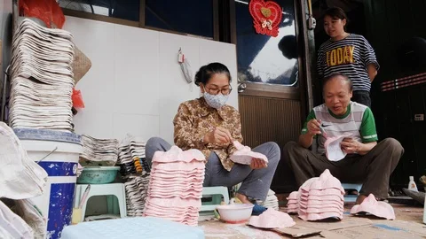 Handheld shot of native vietnamese people sealing handmade full face masks Stock Footage 147373371