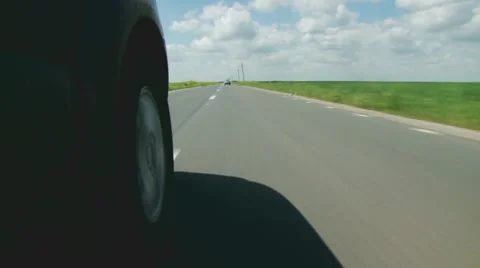 Handheld shot near Wheel on Road Between Crops Stock Footage 43051630