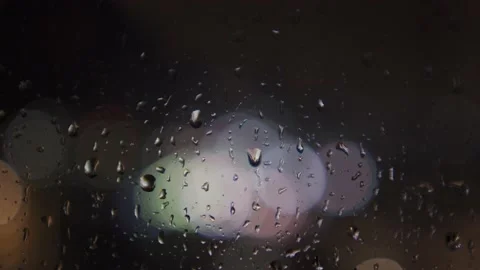 Handheld shot of nighttime rainy window with gentle drizzle and bokeh background Stock Footage 157666175