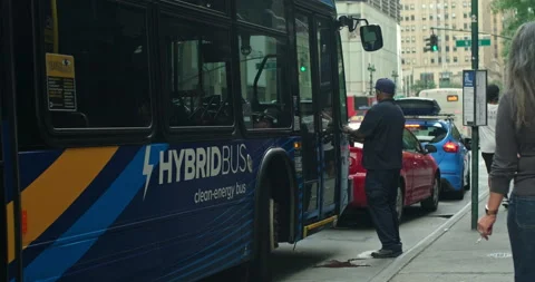 Handheld shot of NYC bus driver entering his NYC public hybrid passenger bus Stock Footage 200525893