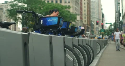 Handheld shot of parked NYC Electric Citi Bikes at parking station Stock Footage 200779461