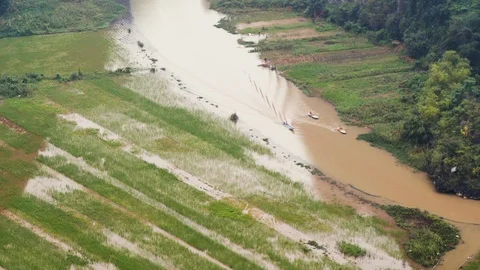Handheld shot of people rowing on red river going through ninh binh province Stock-Footage 147351104