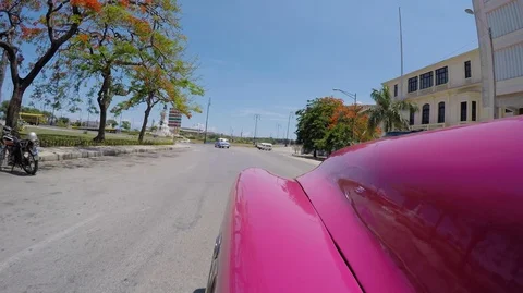 Handheld shot from pink car of cuban roads with other cars passing by, Cuba Stock Footage 141668341