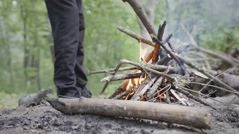 Handheld shot of preparing and lighting up a small fire in the tourist camp in Stock Footage 161892403