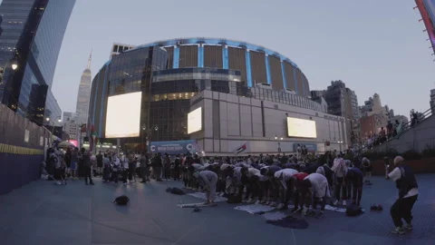 Handheld shot of pro-palestinian protesters praying outside of Madison Square Stock Footage 278955794