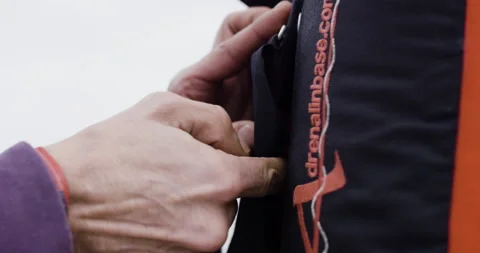 Handheld shot of pro surfer Bruno Valente putting on jumping harness on friend Video stock 158713920