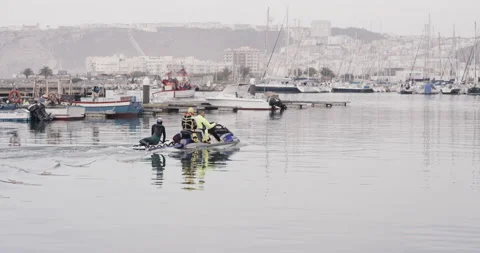 Handheld shot of pro surfer David Langer driving jet ski with two other surfers Video stock 160525056