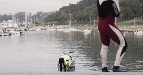 Handheld shot of pro surfer David Langer setting up jet ski with another surfer Stock Footage 160536127