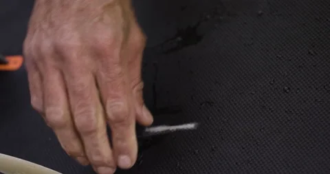 Handheld shot of pro surfer David Langer showing off big scratch on his board Video stock 160538374