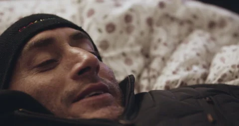 Handheld shot of pro surfer David Langer laying in bed and speaking over phone Stock Footage 160552581