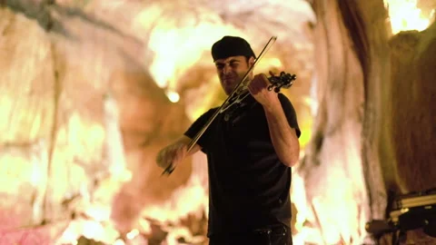 Handheld shot of pro surfer Nuno Santos passionately playing violin during night Stock Footage 155256726