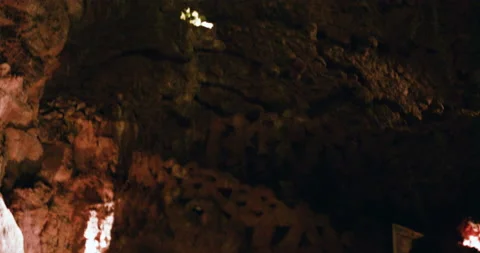 Handheld shot of pro surfer Nuno Santos playing violin inside underground caves Stock Footage 155257502