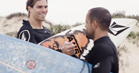 Handheld shot of pro surfer Nuno Santos talking to fellow surfer Alex Botelho Stock Footage 158701556