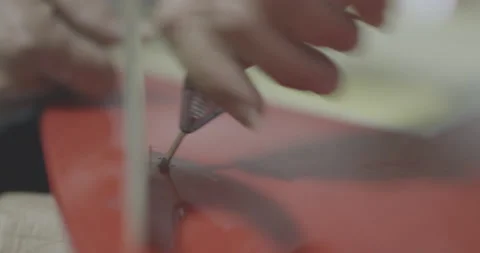 Handheld shot of pro surfer Ross Clarke-Jones adjusting nuts and screws on board Stock Footage 160111708