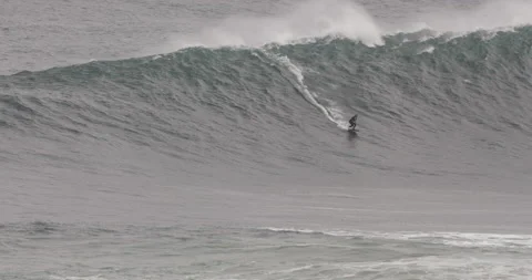 Handheld shot of pro surfer using jet ski in ocean keeping other surfer in check Stock Footage 163298882