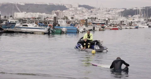 Handheld shot of professional surfer David Langer sitting on jet ski in harbour Stock Footage 160532959