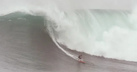 Handheld shot of professional surfer jumping on surfboard in middle of wave Stock Footage 163306316