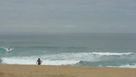 Handheld shot of professional surfer running into cold ocean enthusiastically Stock Footage 158652385