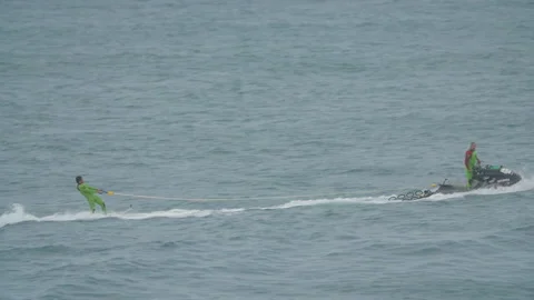 Handheld shot of professional surfer strapped behind jet ski on atlantic ocean Stock Footage 158652019