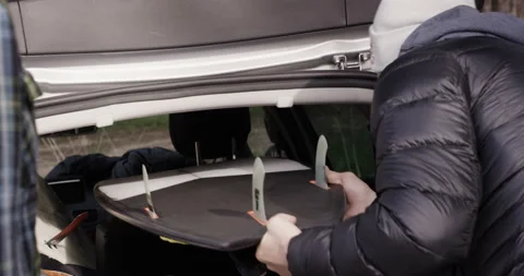 Handheld shot of professional surfers loading surfing things into back of car Stock Footage 160513037