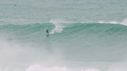 Handheld shot professional surfers using help of jet ski to get carried around Stock Footage 157156973