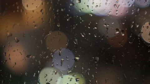 Handheld shot of rainy window panning down with city light bokeh circles Stock Footage 157666165