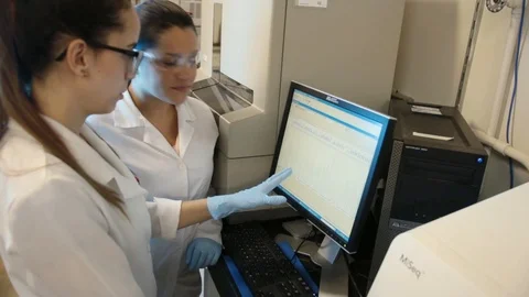 A handheld shot of a researcher checking a DNA sequencer a genetic laboratory at Stock Footage 97738359