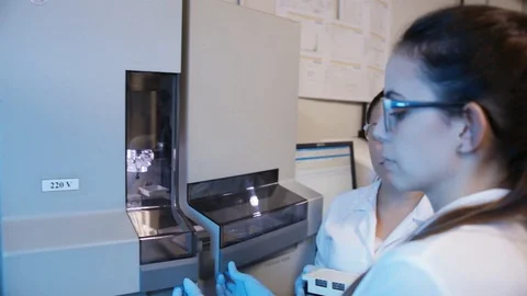 A handheld shot of a researcher checking a DNA sequencer a genetic laboratory at Stock Footage 97738377