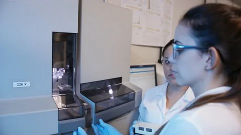 A handheld shot of a researcher checking a DNA sequencer a genetic laboratory at Stock Footage 97738970