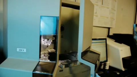 A handheld shot of a researcher checking a DNA sequencer a genetic laboratory at Stock Footage 97739241